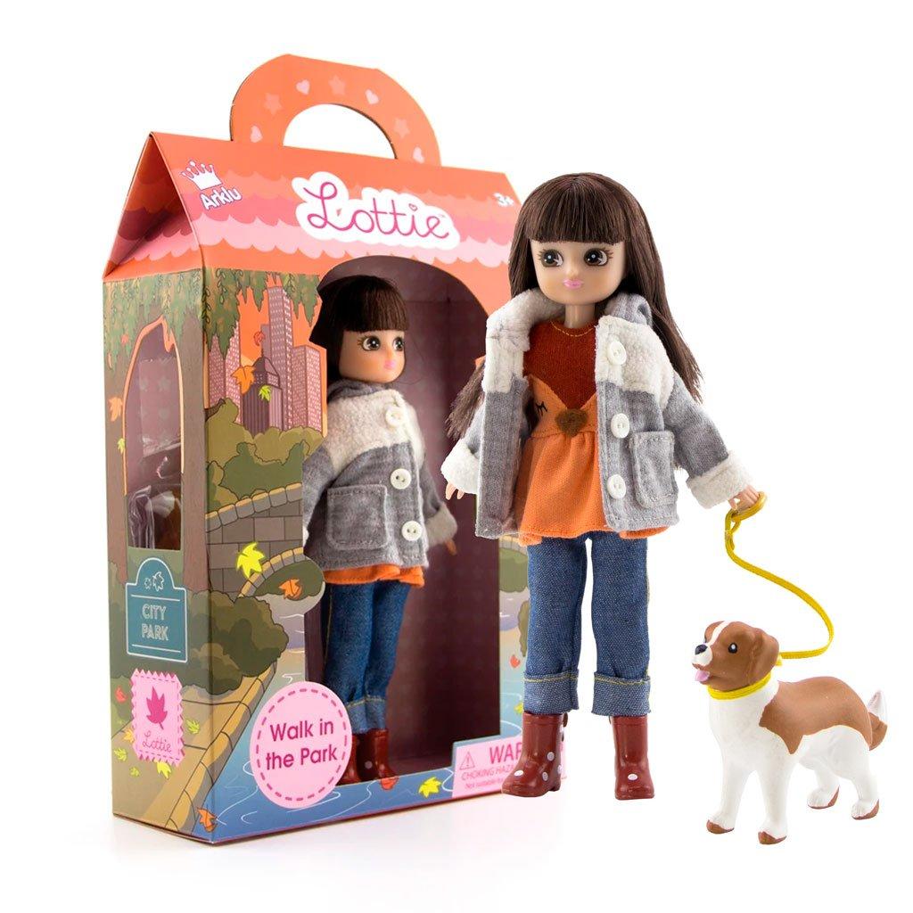 Lottie doll with dog on lead with packaging in background.