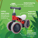 The Boldcube Baby Balance Bike - Betty Ladybird with gray wheels is shown on a green jungle background with leaves. It offers 180° limited steering, a carbon steel frame, plush seat, and silent wheels—ideal as a first birthday gift.