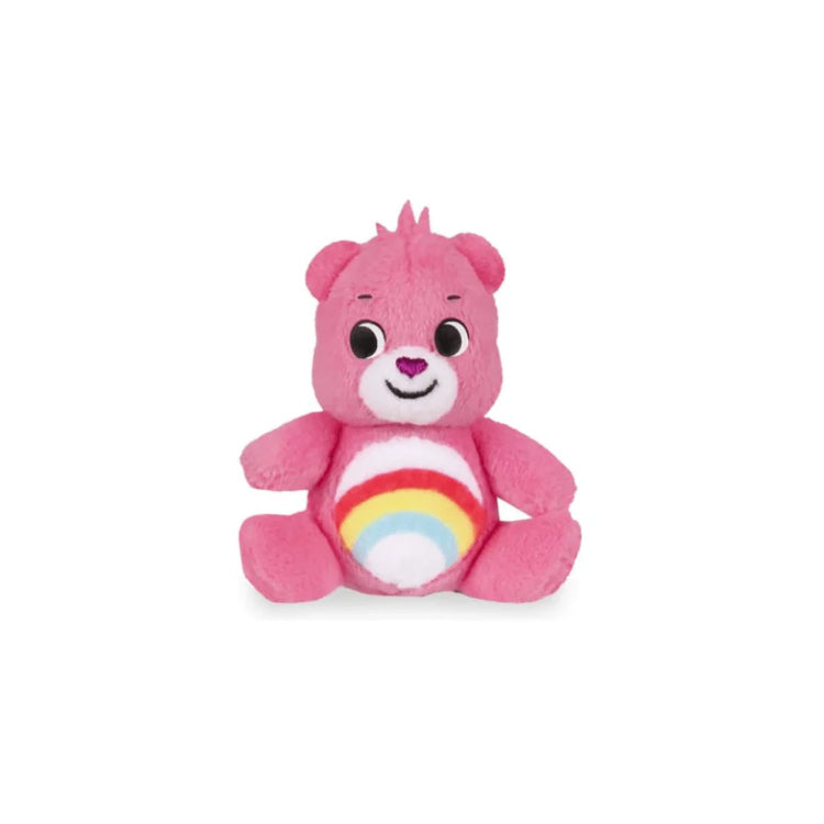 The Care Bears Mini Classics Micro Plush 3-Pack by Basic Fun includes a charming pink plush teddy bear that sits upright and features a friendly smile with round eyes. It boasts a colorful rainbow design on its belly, reminiscent of the classic Care Bears style, making it an ideal addition to any micro plush toy collection, presented against a plain white background.