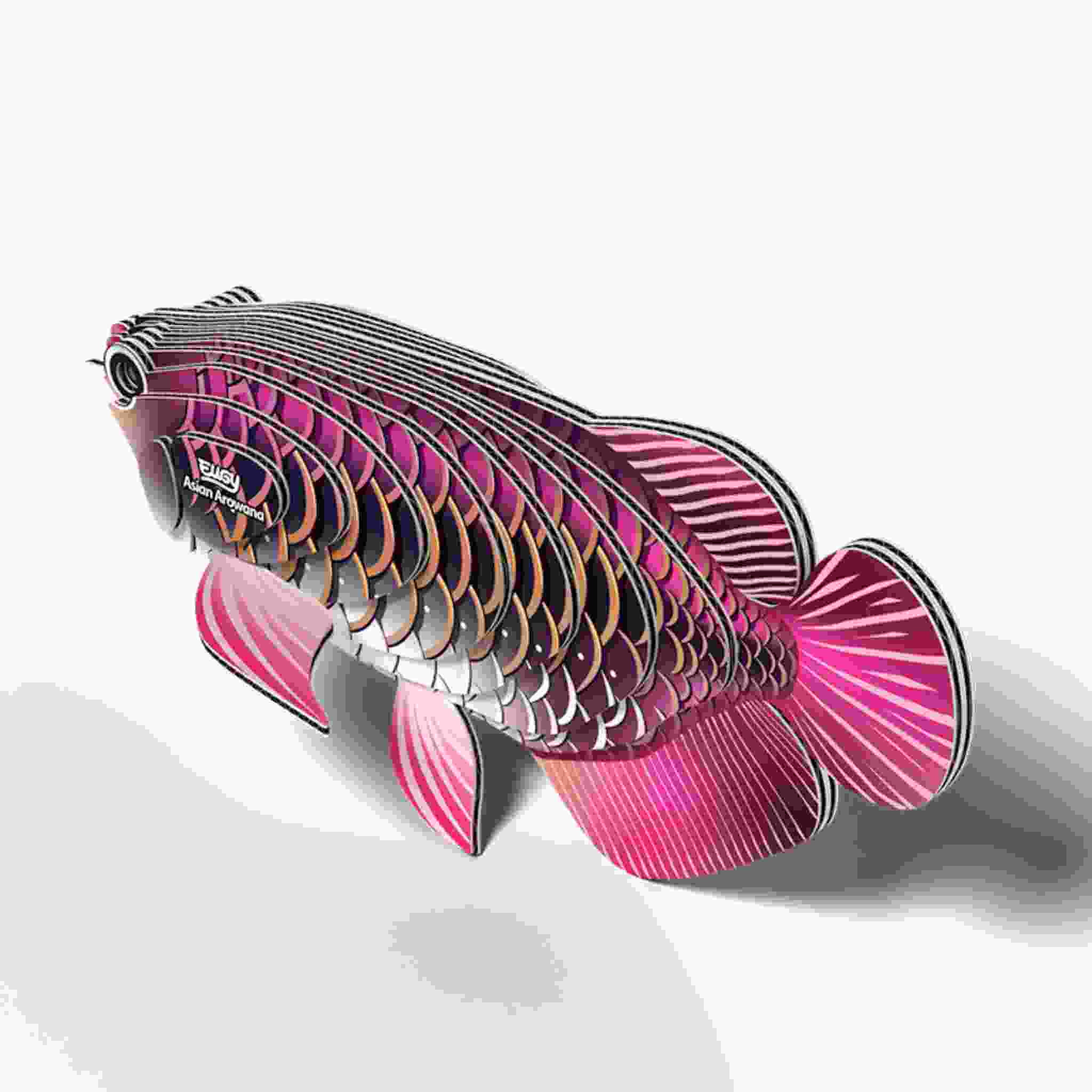 The EUGY Asian Arowana is a vibrant, multi-layered fish sculpture with pink, purple, and metallic hues. It boasts intricate scale designs and geometric patterns similar to classic Eugy figures, all set against a clean white background.