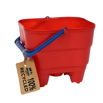 The Eco 100% Recycled Castle Bucket by Crazy Coast is a red plastic children's product with a blue handle and brown tag that reads "100% Recycled," eco-friendly and made from recycled materials.