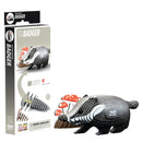 The EUGY Badger cardboard model kit highlights a delightful black and white badger made from sustainable materials, with mushrooms depicted on the packaging. After assembly, this EUGY toy figure stands proudly next to its box, which displays construction steps and part number 094 with clear labeling.