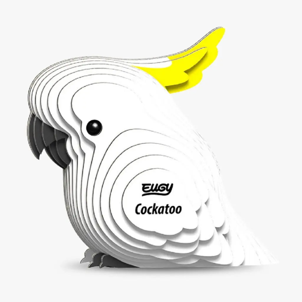 The EUGY Cockatoo is a stylized figurine crafted from layered white sheets with a yellow crest, eco-friendly puzzle design featuring "EUGY Cockatoo" on its side. Its black beak and eye contrast against the plain white background.