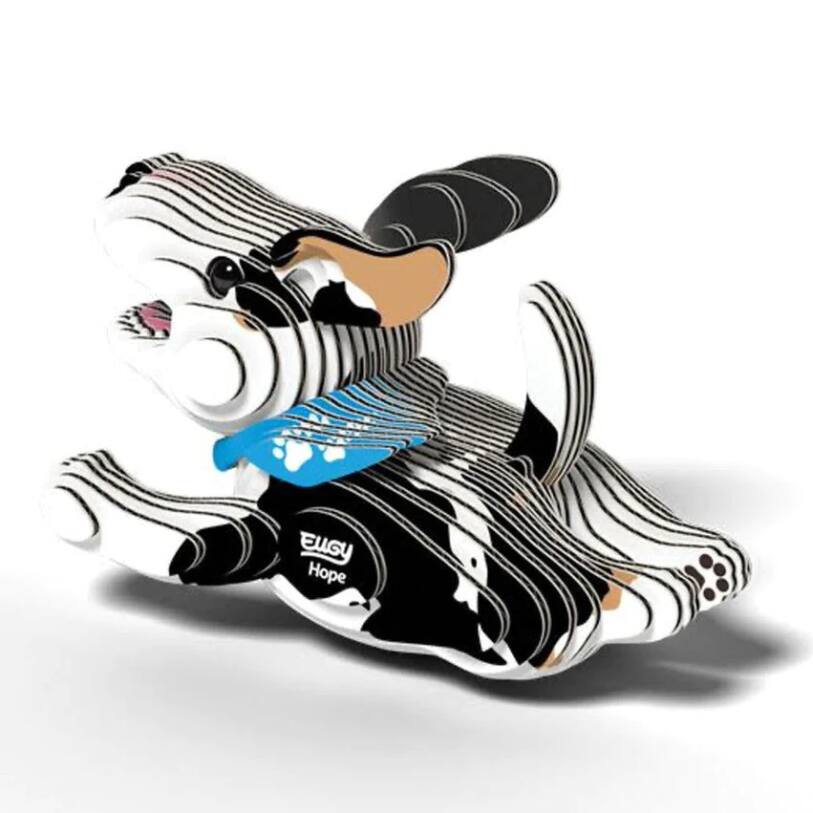 Introducing the EUGY Dog - Hope by EUGY, a stylized 3D sculpture crafted from stacked layers of recyclable card. This playful design showcases a dog wearing a blue bandana and depicted in motion, complete with animated ears and tail. The sculpture features an eye-catching combination of black, white, and tan colors.