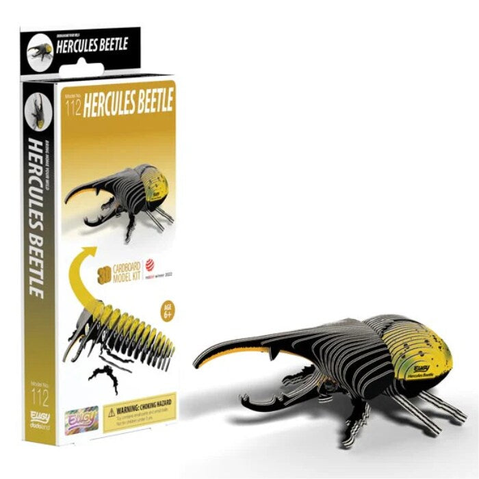 An eco-friendly cardboard kit called the EUGY Hercules Beetle, part of the EUGY figures collection, is displayed alongside its packaging. The model boasts a striking yellow and black color scheme and is suitable for ages 6 and up. The packaging features an image of the finished beetle along with assembly instructions.