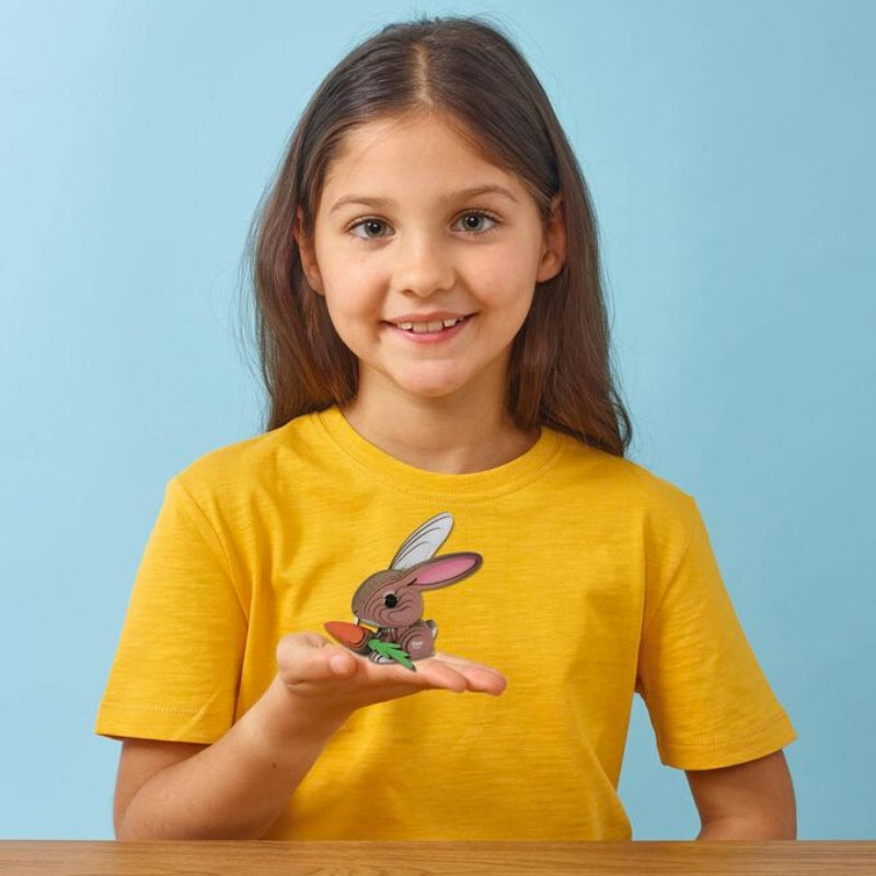 Brown-haired Girl in a yellow t-shirt holding a model of the Eugy rabbit in her hand.