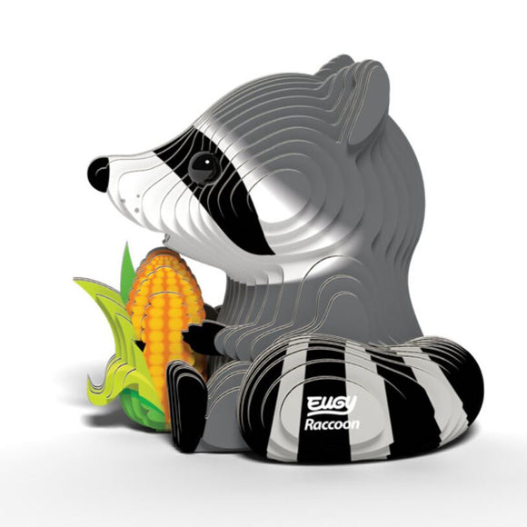 An illustration of a stylized gray raccoon holding an ear of corn with a leafy husk showcases a smooth, layered appearance and is labeled "EUGY Raccoon." This eco-friendly collectible piece from EUGY adds charm to any collection.