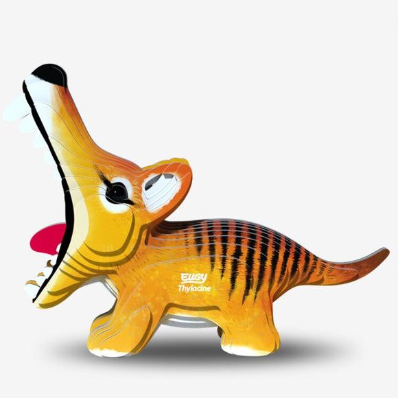 Description of a whimsical EUGY Tasmanian Tiger featuring an inflatable, cartoon-like design with its mouth playfully open. It exhibits vibrant orange, yellow, and black stripes with a red tongue visible inside. Crafted from biodegradable material, the side is adorned with the text "Thylacine.