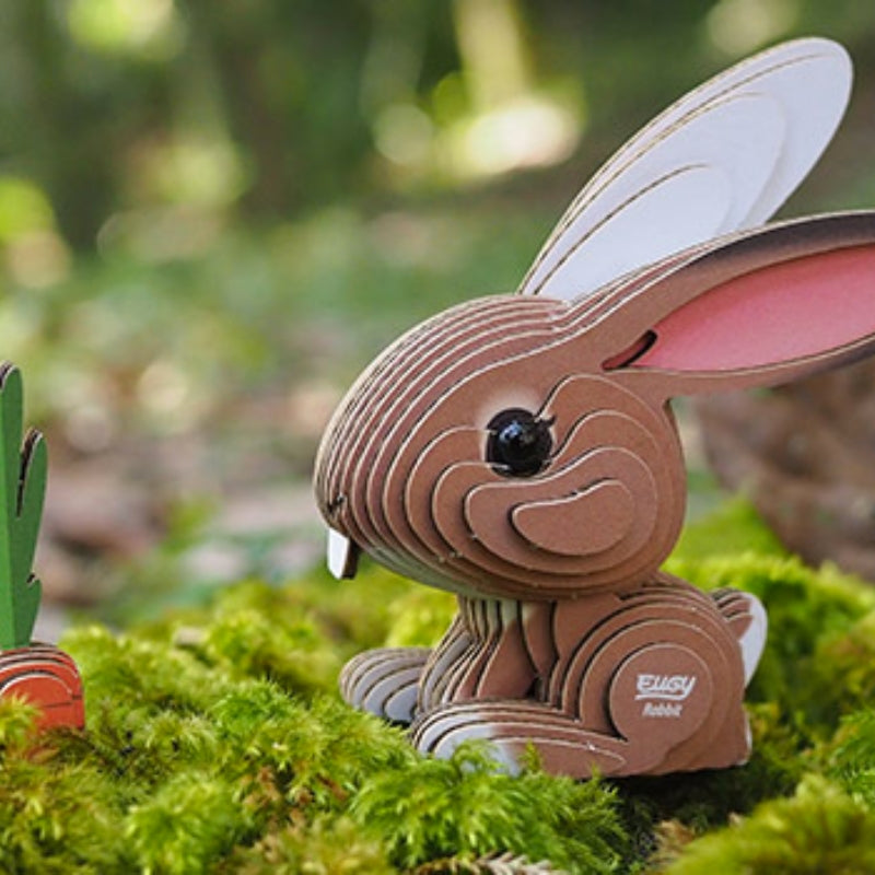 Eugy model cardboard rabbit sitting on moss.