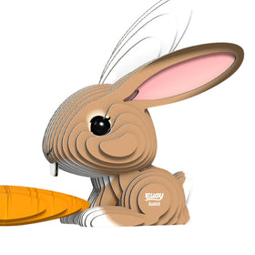 Brown cardboard model rabbit with a carrot at its paws.