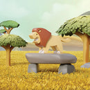 The Halftoys Diorama - Lion by Halftoys features a stylized cartoon lion on a stone slab in golden grass, surrounded by green trees and a cloudy sky, evoking the charm of animal-themed playsets.