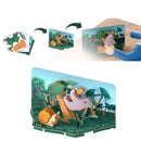 A hand assembles the Halftoys Diorama - Sloth by Halftoys, creating a 3D pop-up jungle scene from flat cards with a bird and snail among trees and bushes—perfect for creative play.