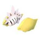 Two yellow and white Halftoys by Halftoys are displayed on a white background: the Diorama - Stego, a stegosaurus figure with white plates, and a smooth, rounded seal-like creature.