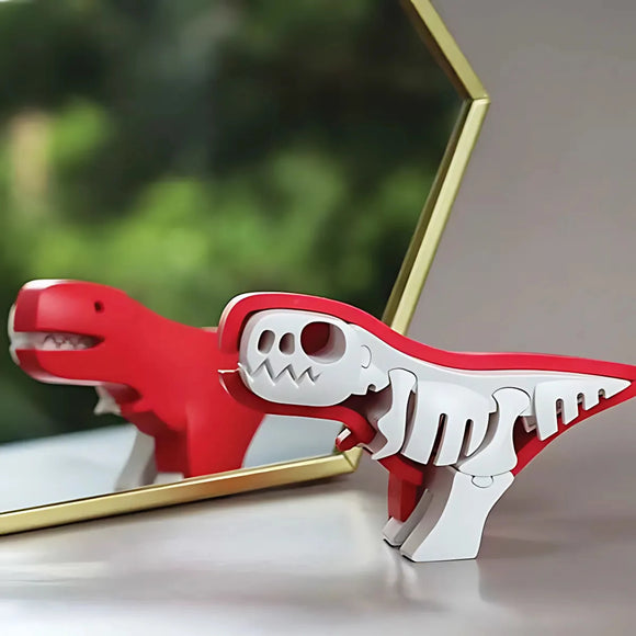 The Halftoys Diorama - T-Rex by Halftoys, a red and white toy dinosaur with a skeleton design, stands before a hexagonal mirror showing its reflection. The educational toy is set against a blurred green and neutral-toned background.