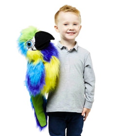 Child holding a colourful blue and, yellow and green parrot puppet against a white background