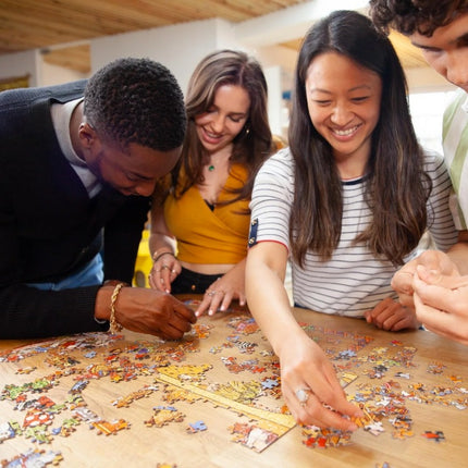 Adults smiling as they put together the Mayhem at the Library jigsaw puzzle.