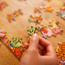 Close up of a hand holding a jigsaw piece.