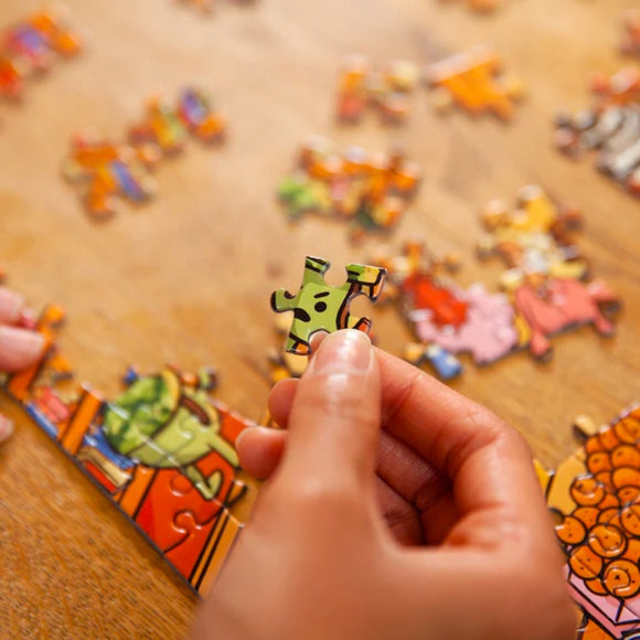 Close up of a hand holding a jigsaw piece.