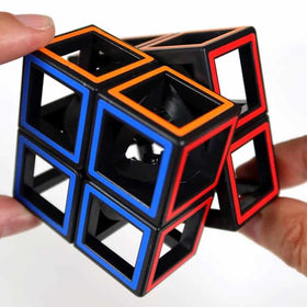 Close-up of hands holding a Meffert - Hollow 2 x 2 Cube Puzzle from MEFFERT'S PUZZLES, featuring blue and red outlined edges. The cube's open-frame structure reveals its inner mechanical core. The background is plain white, emphasizing the unique design of this twisty puzzle.
