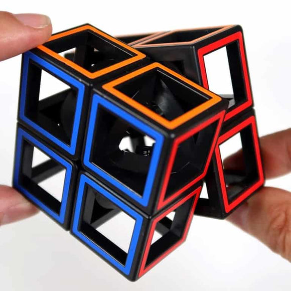 Close-up of hands holding a Meffert - Hollow 2 x 2 Cube Puzzle from MEFFERT'S PUZZLES, featuring blue and red outlined edges. The cube's open-frame structure reveals its inner mechanical core. The background is plain white, emphasizing the unique design of this twisty puzzle.