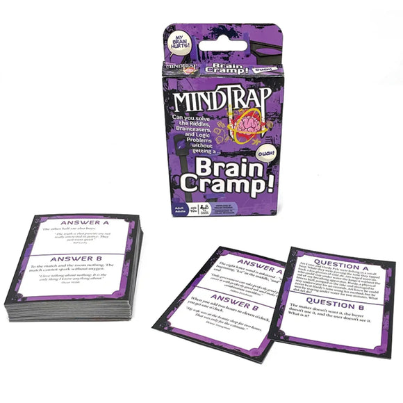 A box of Outset Media's MindTrap Cards Brain Camp card game is displayed with two stacks and two face-up question cards, all in a purple and black design—ideal for fans of brainteasers and riddles.