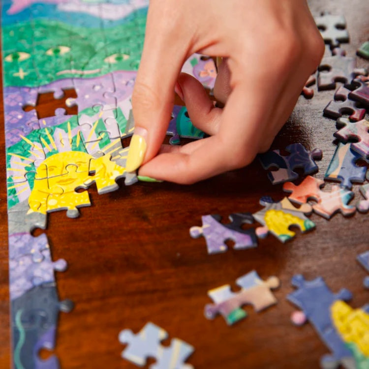 Close-up of a woman's hand placing a piece of jigsaw.