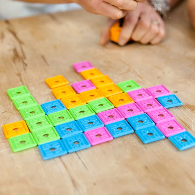 Colourful plastic tiles of the OK Play game laid out.