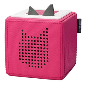 The Toniebox - Starter Set Pink by Tonies is a pink, cube-shaped audio system designed for children. It features a perforated cat silhouette on the front and two gray ears on top. A small side tag reads "toniebox," encouraging kids to dive into imaginative stories with their favorite Creative-Tonie characters.