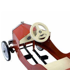The Vilac Large Pedal Car in red is a vintage-style metal ride featuring a cream steering wheel and black controls. Its classic open-body design reveals a timeless look for budding drivers.
