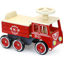 The Vilac Ride-On Fire-truck, made from sustainably-sourced wood, features a red and natural finish with a steering wheel, seat, and four black wheels with red hubcaps. It includes white fire department insignia and the number 39, making it an eco-friendly and fun toy.