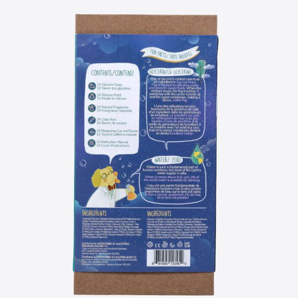 The image shows the back of a KISS NATURALS DIY Natural Glycerin Soap Kit box, featuring colorful illustrations and text. A cartoon scientist character holding a flask is depicted on the bottom left. The contents, instructions, DIY soap-making tips, all-natural ingredients, and safety information are listed in multiple languages against a blue background.