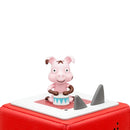 A small, pink cartoon figure resembling a pig sits on a red platform. With a cheerful expression, it's holding a drum, ready to lead children's music. The platform has two gray, triangular shapes beside the figure, inviting kids to sing along to fun animal-themed songs from the Tonie - Favourite Children's Songs - Animal Songs by Tonies.