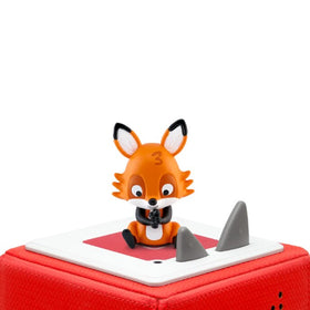A small, cartoon-like fox figurine with closed eyes is perched on a red speaker box, crafted for educational singing experiences. The orange-furred fox features a bushy tail and black-tipped ears, encouraging children to discover multilingual counting with the engaging Tonie- Favourite Children's Songs - Counting Songs by Tonies. The background is white.