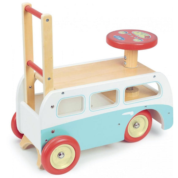 The Vilac 2-in-1 Retro Wooden Camper Van features a campervan-style design with red wheels, a teal and white body, and a red steering wheel. It has a rectangular shape with curved edges and includes a wooden handle for pushing.