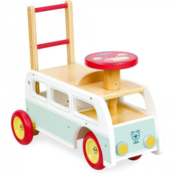 The Vilac 2-in-1 Retro Wooden Camper Van is a colorful toy with red wheels, a red steering wheel, and a white body adorned with light blue accents. It features a seat and handle for young children to ride or push.