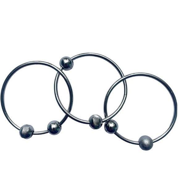 Three YUMMIKEYS Yummirings - Stainless Steel Teething Rings feature spherical beads spaced at intervals, arranged in a neat, overlapping manner against a white background. Each ring has subtle design variations with different bead textures, making it an ideal multi-sensory toy for teething gums.