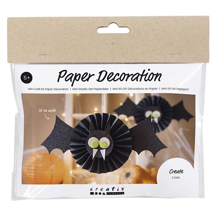 The Mini Craft Kit Paper Decorations, Bat by Creativ Company includes a DIY set to make two black bats with green eyes. Perfect for ages 5 and up, the background displays a room decorated with similar bats.