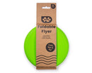 The Toy Shop's Foldable Flyers, a bright green foldable flying disc for ages 12 months and up, is crafted from eco-friendly materials. Partially visible in its cardboard packaging, it features "Fold, flex & fly!" on the front to emphasize its reusability.