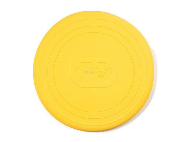 The Toy Shop offers Foldable Flyers, a yellow silicone frisbee with embossed concentric circles and a "BIGJIGS" logo in the center, providing an eco-friendly toy option.