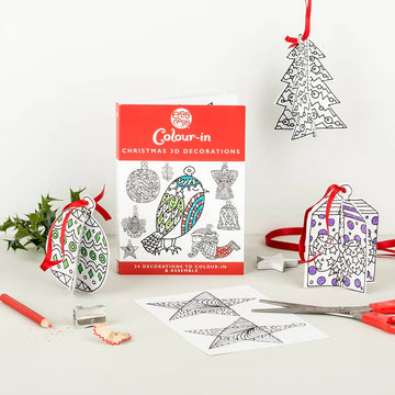The Eggnogg Card Book - 3D Christmas Decorations by Eggnog features color-in Christmas ornaments, a present, and a tree with red and purple accents. It includes examples for coloring and comes with scissors and pencils, ideal for children's festive activities.