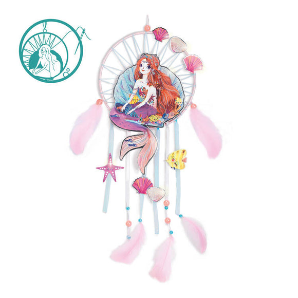 The DIY Mermaid Dreamcatcher by Djeco showcases a vibrant design with a mermaid centerpiece, pink feathers, seashells, and a starfish. It also features a teal mermaid motif on the top left, perfect for adding an enchanting touch to any space.