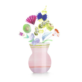 An illustration featuring Djeco's DIY Paper Flower Bouquet shows a pink vase filled with an assortment of colorful, abstract paper flowers and leaves. The bouquet includes flowers shaped like circles, fans, and triangles in vibrant tones such as purple, green, and blue. This design embodies a modern and whimsical style reminiscent of a creative kit.