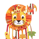 The Djeco DIY Lion Dreamcatcher features a vibrant stylized lion face with a crown, surrounded by a colorful mane. Ribbons adorned with leaf and flower decorations hang below, while an inset displays a bird and leaf design.