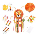 The Djeco DIY Lion Dreamcatcher is a kids' craft kit perfect for developing fine motor skills. It includes a lion face with a crown, colorful threads, leaf shapes, and adhesive stickers. The design features vibrant hanging leaves in orange, yellow, and brown.