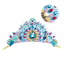 The Djeco DIY Mosaic Tiaras feature a colorful, ornate peacock-themed design with blue, pink, and gold patterns, gemstone stickers, and intricate details including feathers.