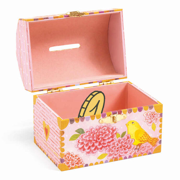 The Djeco Birds Money Box is a charming decorative wooden piggy bank, painted in soft pink with floral patterns and a yellow bird illustration. The inside matches the exterior hue and includes a coin slot on its lid, making it both functional and delightful.