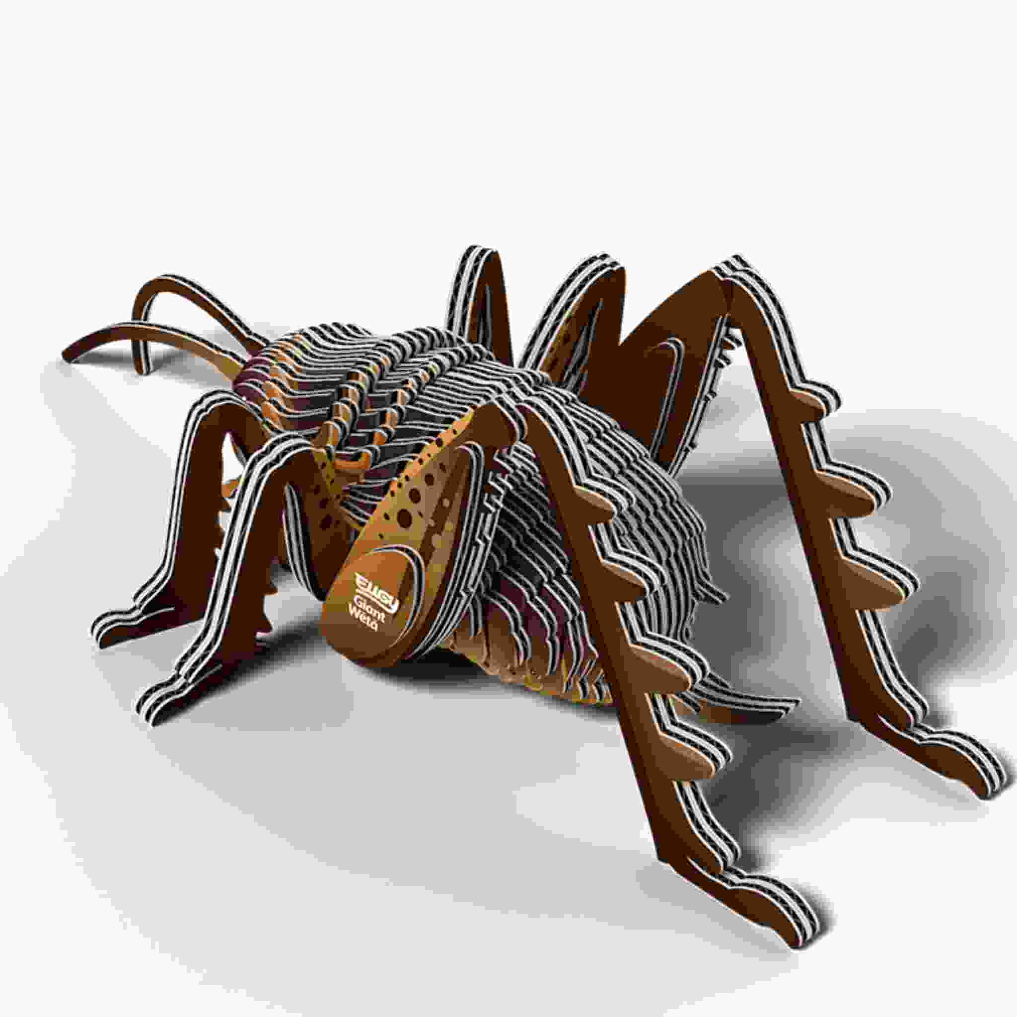 The EUGY Giant Weta is a 3D model resembling a large brown spider with segmented body parts, detailed legs, and striped design. It offers an artistic and mechanical look and is crafted using non-toxic glue for safe assembly, similar to Eugy figures or construction toys.