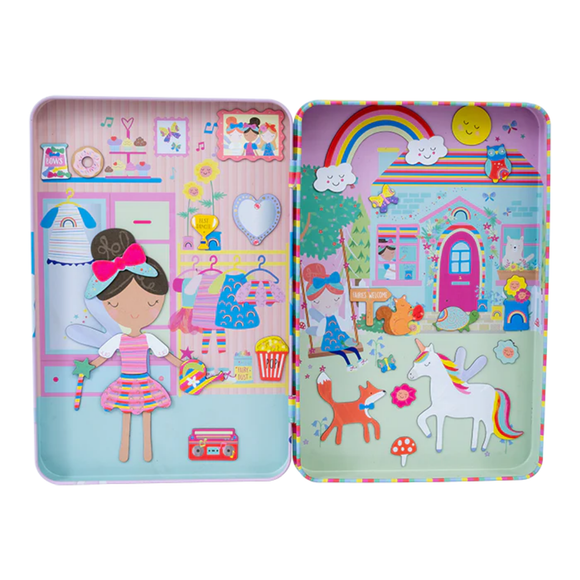 Introducing the Rainbow Fairy Magnetic Playtime by Floss & Rock: a vibrant tin box made from recycled materials, showcasing two charming scenes. On one side, discover a girl with a bow in her hair amidst clothes and accessories, while the other side depicts a magical garden complete with animals, a rainbow, and a unicorn.