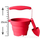 The SCRUNCH Mini Bucket & Spade, ideal for young gardeners, is a red collapsible silicone bucket with a handle and small red spade attached. It's labeled "Scrunch," stands 25 cm tall, and is perfect for creative outdoor play.