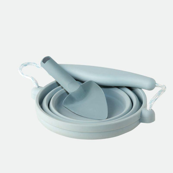 The SCRUNCH Scrunch Mini Bucket & Spade set includes gray collapsible silicone kitchen tools like a spatula and flexible funnel that neatly stack together. Each item features white rope handles for easy hanging and storage, resembling a versatile silicone bucket.
